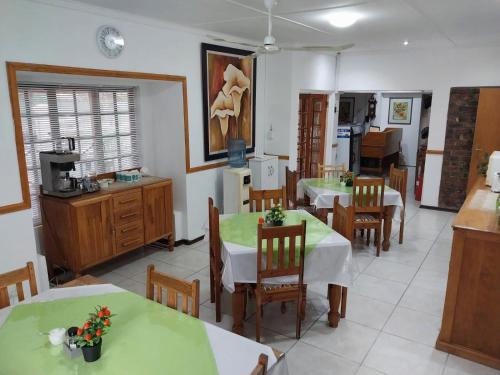 a kitchen and dining room with two tables and chairs at Lily Guesthouse in Bloemfontein