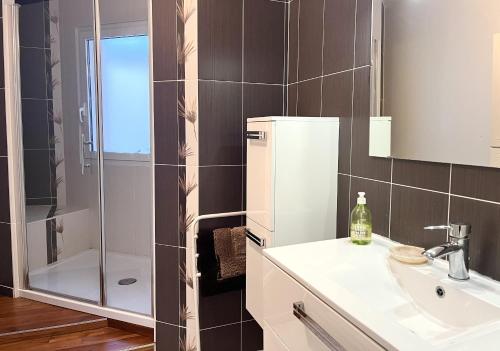 une salle de bain avec un lavabo et une douche dans l'établissement Spacieux appartement dans le centre-ville des Sables d'Olonne - 4 pers, à Les Sables-dʼOlonne