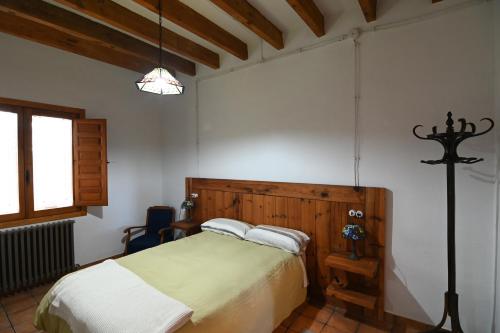 um quarto com uma cama com uma cabeceira de madeira em Armonía y naturaleza: La Cañada em Cenizate