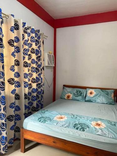 a bedroom with a bed with blue and white curtains at Friendly Transient House in Puerto Princesa City