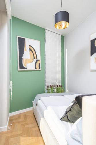 a bedroom with a white bed and green walls at Apartamenty Olimpijska by RENT4YOU in Olsztyn