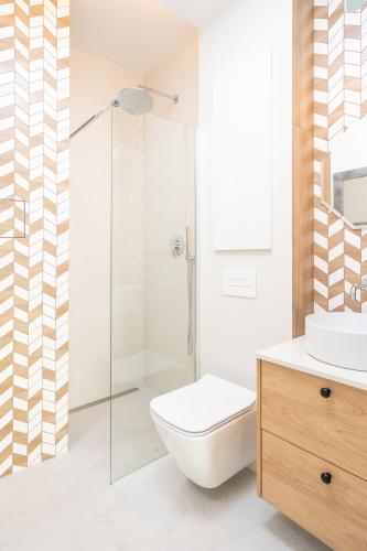 a bathroom with a shower and a toilet and a sink at Apartamenty Olimpijska by RENT4YOU in Olsztyn