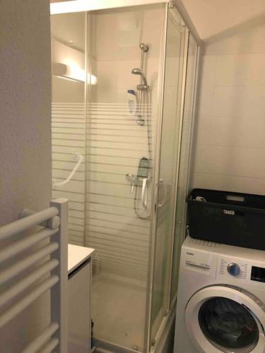 une salle de bain avec douche et machine à laver dans l'établissement Appartement face à la mer canet en Roussillon, à Canet