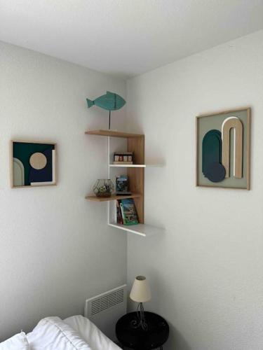 - une chambre avec un lit et des étagères sur le mur dans l'établissement Appartement face à la mer canet en Roussillon, à Canet