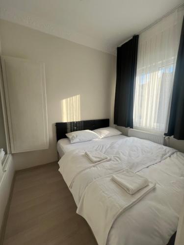 1 dormitorio con 2 camas y toallas. en DERVİŞ BEY KONAĞI, en Estambul