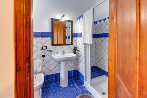 a blue and white bathroom with a sink and a toilet at Case Vacanze Castellana Iris in Sciacca