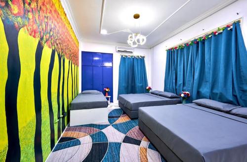 a bedroom with two beds and a painting on the wall at Penang Dream Banglo Sleeps 28 in Tanjung Bungah
