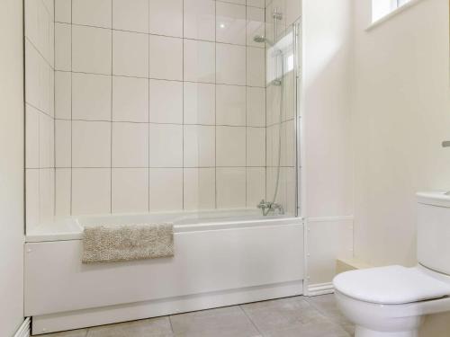 a white bathroom with a tub and a toilet at 1 Bed in Aberdare 82906 in Merthyr Tydfil