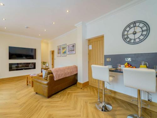 a living room with a couch and a clock on the wall at 1 Bed in Llandudno 83621 in Llandudno