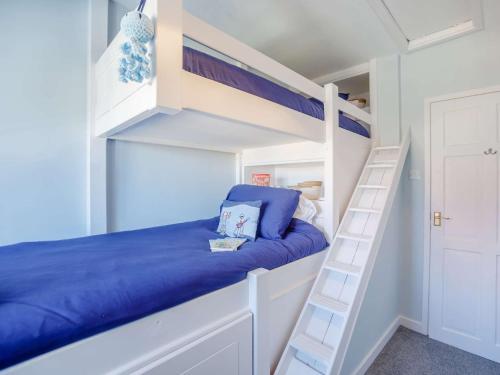 a bunk bed in a white bunk room with a ladder at 2 Bed in Newbiggin-by-the-Sea 83568 in Newbiggin-by-the-Sea