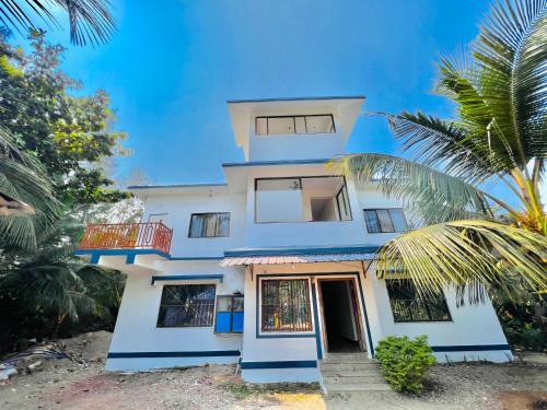 una casa blu con una palma di fronte di Sea Point Villa a Kashid