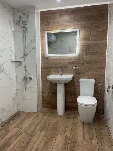 a bathroom with a toilet and a sink at Hotel Rotasar in Sofia