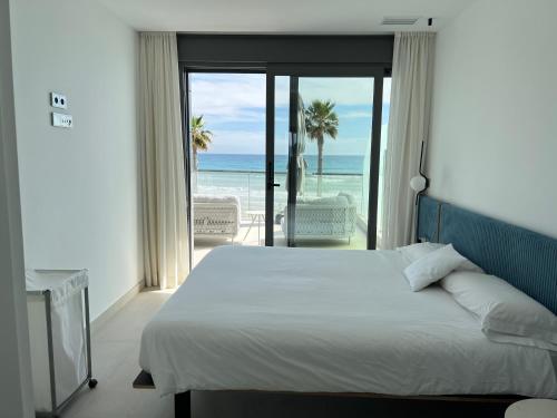 a bedroom with a bed and a view of the ocean at Bungalow de lujo 5* 1ª LÍNEA Playa San Juan in Alicante
