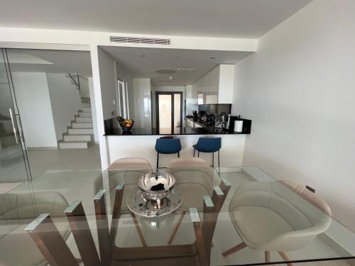 a living room with a glass table and chairs at Bungalow de lujo 5* 1ª LÍNEA Playa San Juan in Alicante