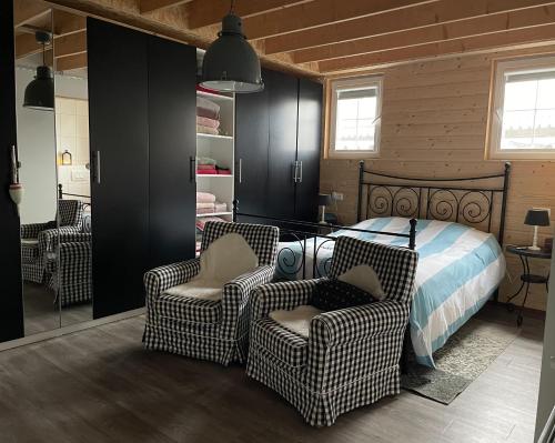 een slaapkamer met 2 stoelen en een bed erin bij Aan de Dijk in Dordrecht