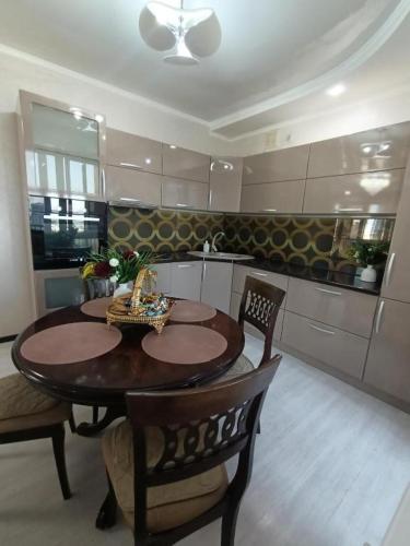 a kitchen with a wooden table and chairs in a room at ВИП КВАРТИРЫ in Kokshetau