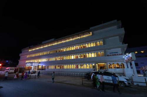 a lit up building with people walking in front of it at Hotel Sangam in Kanyakumari