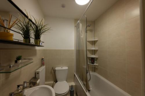 a bathroom with a toilet and a sink and a bath tub at Central Retreat- A Cosy 2 Bedroom Flat with View in L3 in Liverpool
