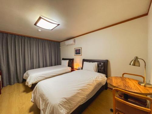 a hotel room with two beds and a table at Hotel Terramar in Boryeong