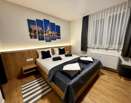 a bedroom with a bed and a painting on the wall at RoomS in Slavonski Brod