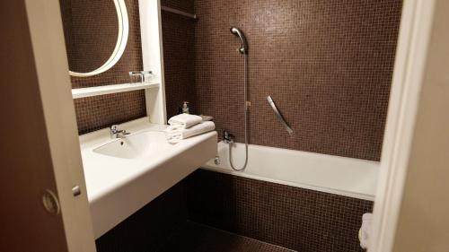 a bathroom with a sink and a shower at HYP'Hotel in Saint-Marcellin