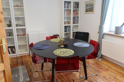 una sala da pranzo con tavolo nero e sedie rosse di Stacija Suntaži viesnīca 