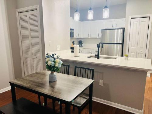 a kitchen with a table with a vase of flowers on it at Relax at Avalon's Best in Orlando