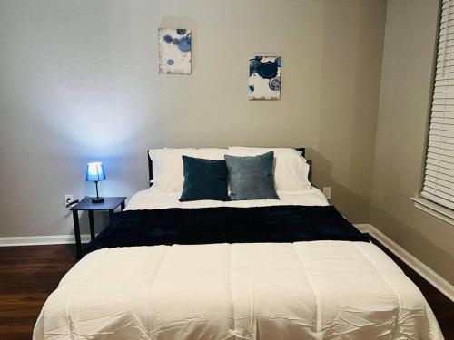 a bedroom with a white bed with blue pillows at Relax at Avalon's Best in Orlando