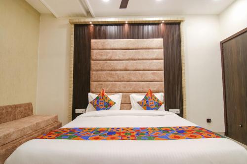 um quarto com uma cama grande e um sofá em FabHotel Spring em Amritsar