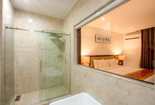 a bathroom with a shower and a mirror at JOHNWOOD HOTEL by Bolton in Wuse