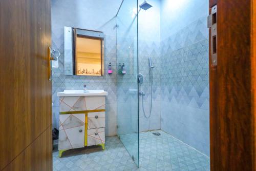 y baño con ducha, lavabo y espejo. en Clay Inn Hotel, Sohna Road, Sector 49, Gurugram, en Gurgaon