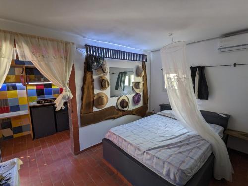 een slaapkamer met een bed en een spiegel met hoeden aan de muur bij La Maison Blanche in Ndangane