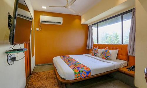 a bedroom with a bed and a large window at FabExpress Jayshree in Mumbai