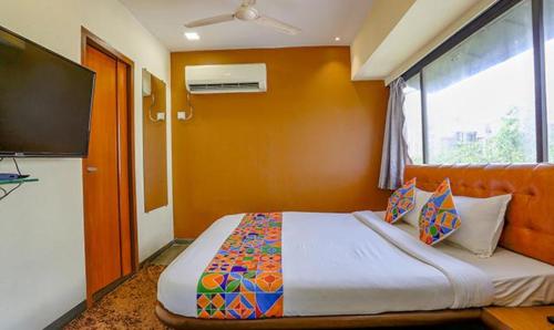 a bedroom with a bed and a large window at FabExpress Jayshree - Nr Mumbai International Airport in Mumbai