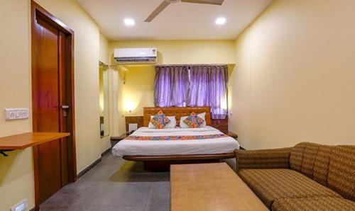 a hotel room with a bed and a couch at FabExpress Jayshree in Mumbai