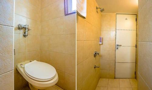 a bathroom with a toilet and a shower at FabExpress Jayshree - Nr Mumbai International Airport in Mumbai
