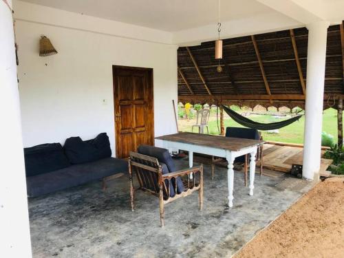 a living room with a couch and a table and hammock at Cute house with salt lake view in Kandakuli