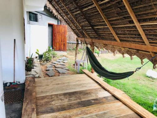 een hangmat hangend aan een veranda van een huis bij Cute house with salt lake view in Kandakuli