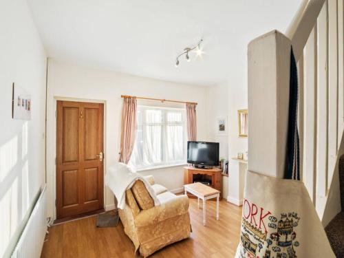 a living room with a chair and a tv at Pass the Keys 55 Heworth Village Wonderfully Cosy Family Home in York in York