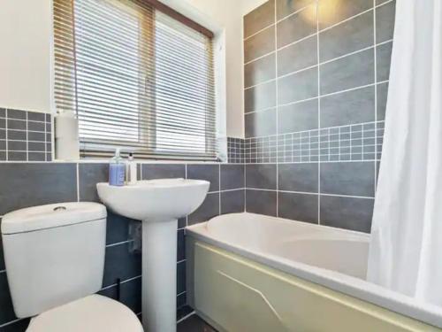 a bathroom with a toilet and a sink and a bath tub at Pass the Keys Wonderfully Cosy Family Home in York