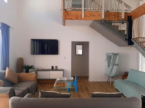 a living room with a couch and a tv at Coastal Cove in St Helena Bay