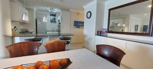 a kitchen with a table with oranges on it at Santorini, Margate in Margate