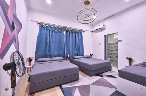 a room with two beds and a fan at Penang Dream Banglo Sleeps 40 in Tanjung Bungah