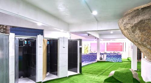 a room with two stalls with green carpet at Penang Dream Banglo Sleeps 40 in Tanjung Bungah