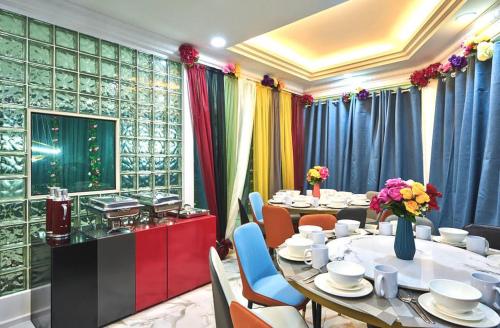 a dining room with tables and chairs and curtains at Penang Dream Banglo Sleeps 40 in Tanjung Bungah