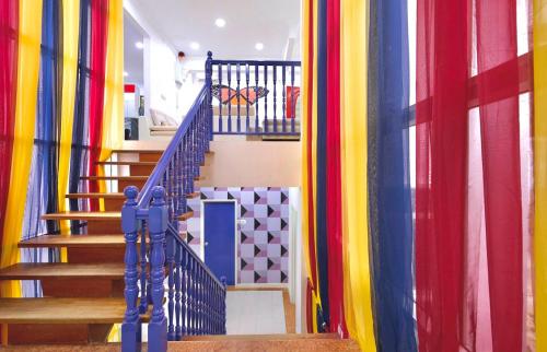 a hallway with colorful curtains and stairs in a house at Penang Dream Banglo Sleeps 40 in Tanjung Bungah