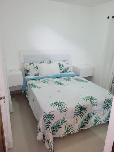 a bedroom with a bed with a tropical print at Serena 4 in Punta Cana