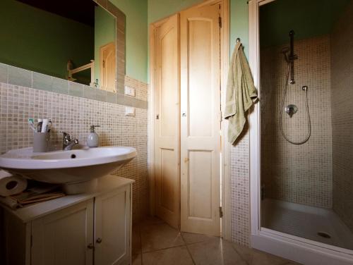 een badkamer met een wastafel en een douche bij Attico Lu Bagnu panoramico in Castelsardo