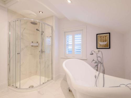 y baño blanco con bañera y ducha. en 5 Bed in Matlock Bath 85188, en Matlock Bank