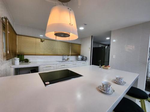 a kitchen with a white counter with two cups on it at HANI Haus in Jeju